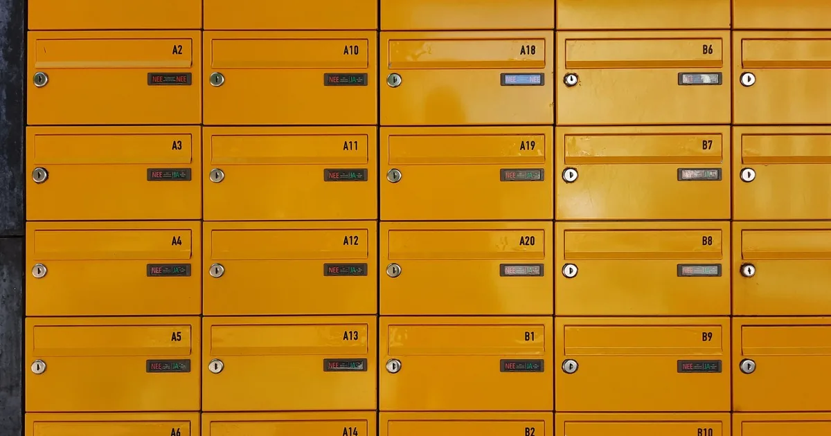 Rows of yellow apartment mailbox doors with individual key locks